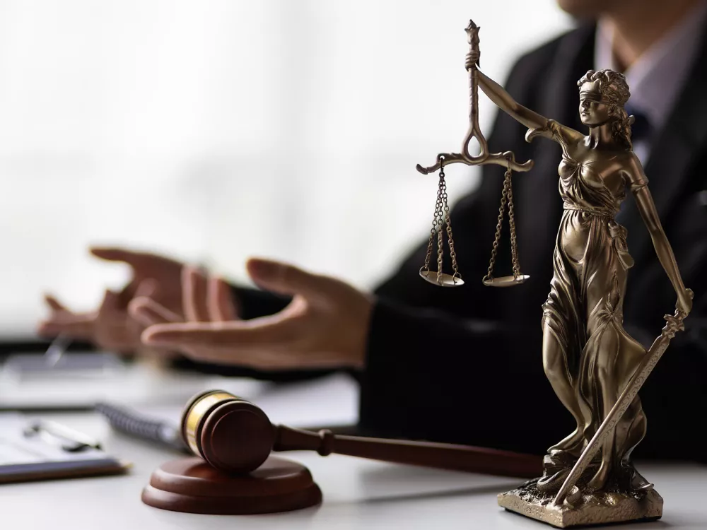 Photo d'une statue de la déesse de la justice posée sur le bureau d'un procureur à Genève