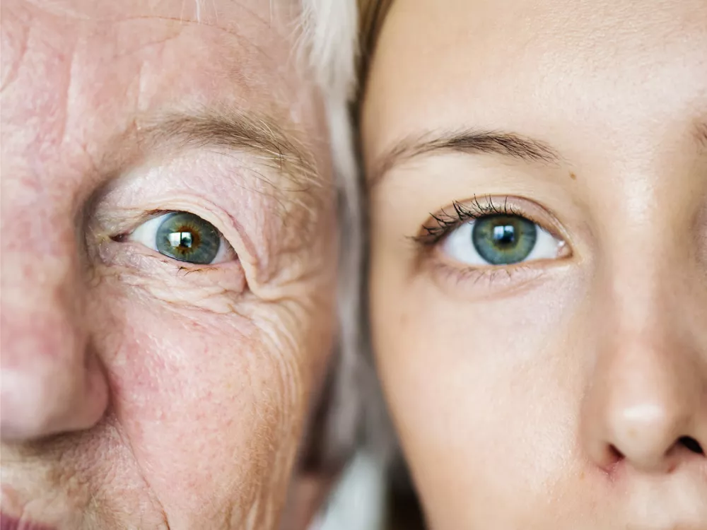 Photo du visage d'une personne âgée et de celui d'une adolescente regardant l'objectif. Elles présentent le vieillissement la population en Suisse.
